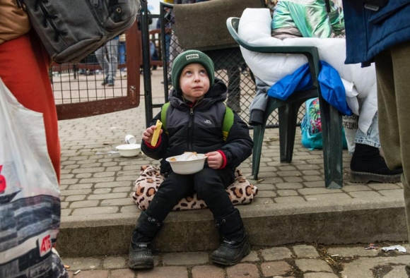 Ein Kind aus der Ukraine erhält auf der Flucht etwas zu essen