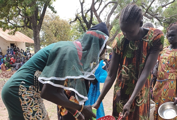 Frauen in Afrika erhalten Lebensmittel wie Maismehl gegen den Hunger